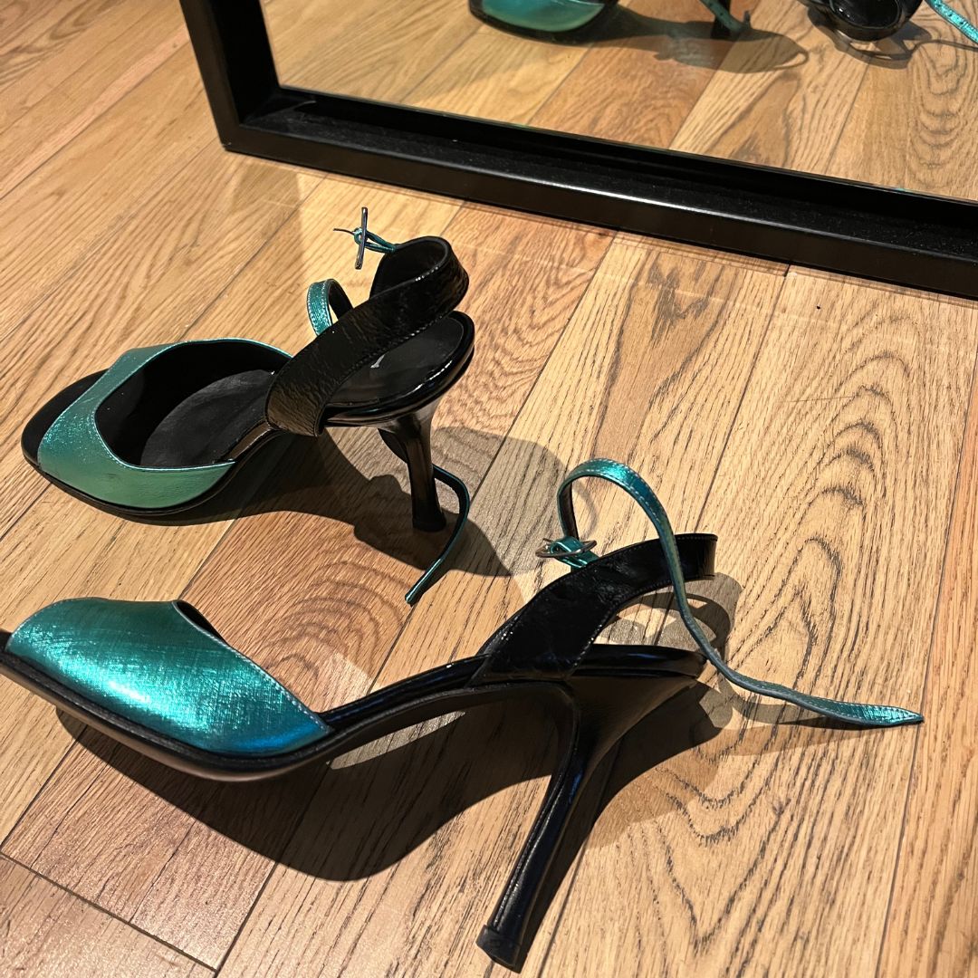 Zwei Paar Tangoschuhe auf dem Holzboden eines Tanzsaals.