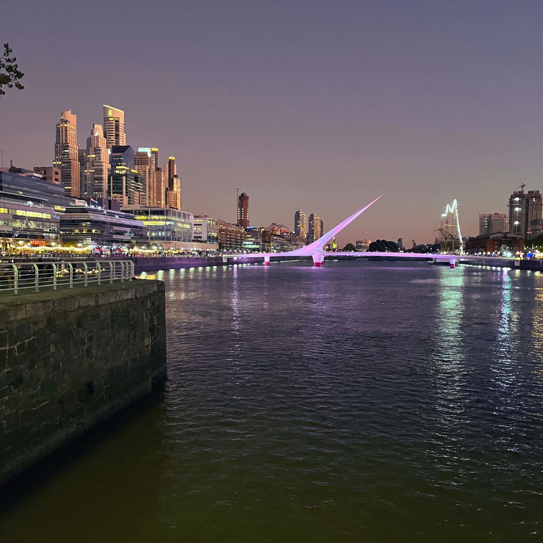 Puerto Madero in Buenos Aires bei Dämmerung, im Wasser spiegelt sich die Puente de la Mujer.